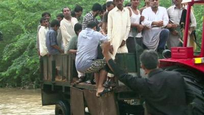 A man gets on a tractor which rescues flood victims in Karachi, Pakistan