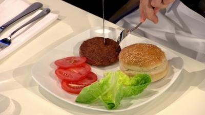 A food critic cuts into the world's first lab-grown burger