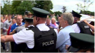 Police escort Lord Mayor of Belfast, Máirtín Ó Muilleoir, through the Woodvale area of the city