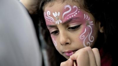 A Muslim girl has her face decorated as Muslims celebrate Eid al-Fitr in Valby, Copenhagen