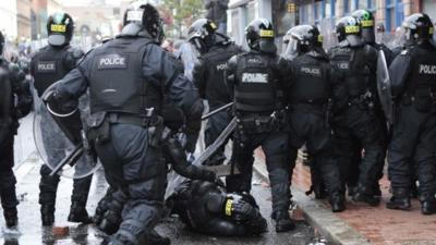 A police officer runs to his injured colleague