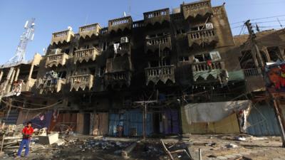 A boy looks at the site of a car bomb attack in the Shaab neighbourhood of northern Baghdad