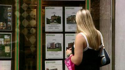 Woman looking at estate agent window