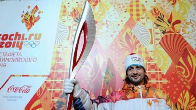 Russian ice dancer Ilia Averbukh poses with a Sochi 2014 Olympic Torch