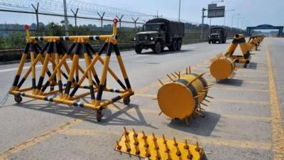 South Korean military trucks drive past barricades on the road linking North Korea's Kaesong Industrial Complex