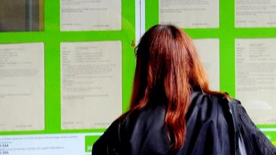 Woman looking in Job Centre window