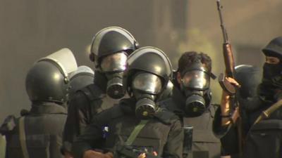 Security forces in Cairo, wearing gas masks and carrying guns