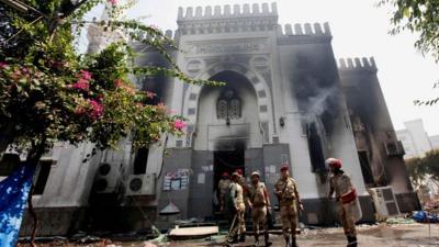 Members of the military police stand outside the burnt Rabaa al-Adawiya mosque