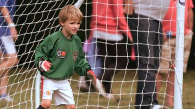 A young boy keeps goal