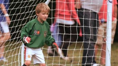 A young boy keeps goal