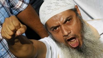 A member of the Muslim Brotherhood and supporter of ousted Egyptian President Mohamed Mursi shouts slogans during clashes in front of Azbkya police station at Ramses Square in Cairo, August 16, 2013