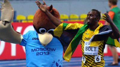 Usain Bolt celebrates with the official mascot of the World Championships