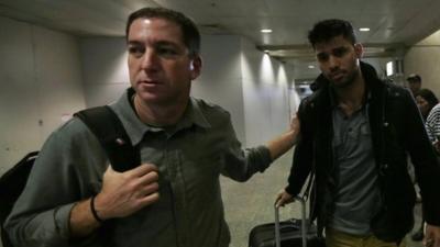 U.S. journalist Greenwald walks with his partner Miranda in Rio de Janeiro's International Airport