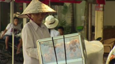 A Vietnamese vendor, selling goods on a street