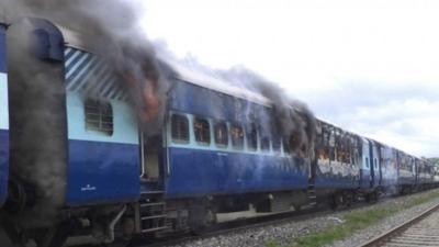 Coaches of the Rajya Rani Express train burn after a mob set it on fire