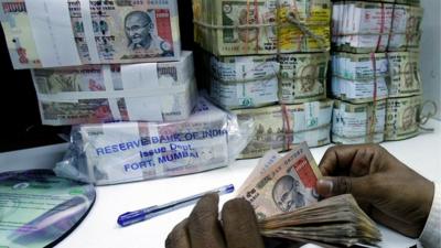 Bank employee counts rupee notes