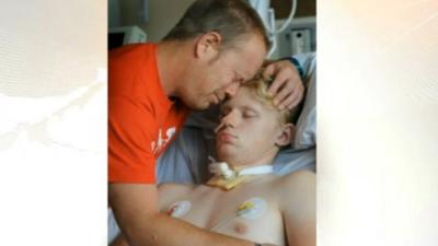 Mark Smith hugs his son, who lies in a coma