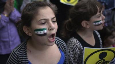 Girl with Syrian flag painted on cheek outside United Nations in New York