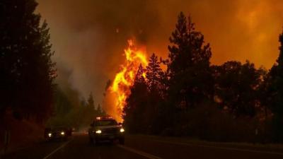 Vehicles on road near fire