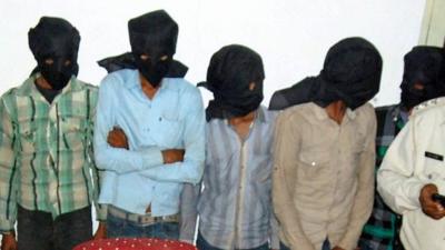 Five hooded suspects during a press meeting in Datia