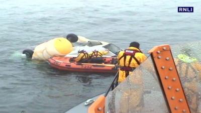 RNLI crew with wreckage of crashed helicopter