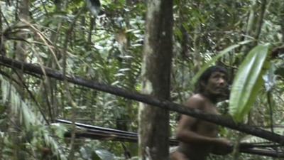 A man from the Kawahiva tribe caught on camera moving through the jungle