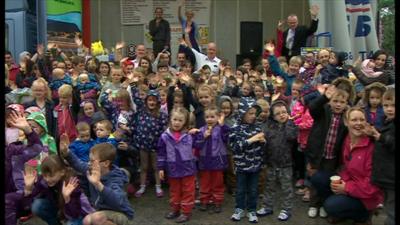 A large group of twins and triplets all waving