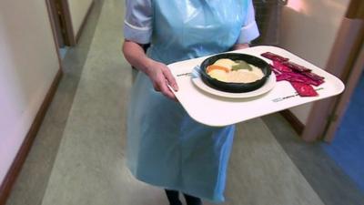 Nurse carrying tray of food