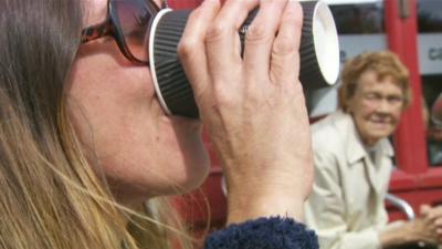 Woman drinking from paper cup