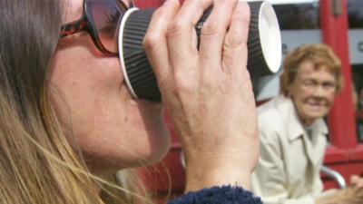 Woman drinking from paper cup