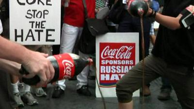 Demonstrators pour Coca Cola down a drain in New York