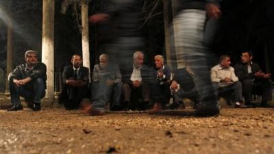 Relatives and locals attend a funeral