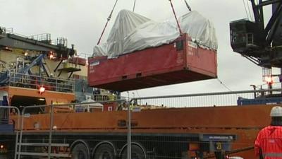 The wreckage being lifted by crane