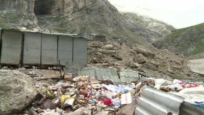 Waste strewn outside a path to the cave