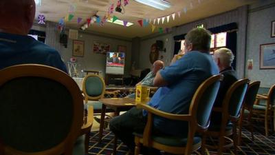 A British Legion Club in Portsmouth. Men sitting on chairs watching the TV