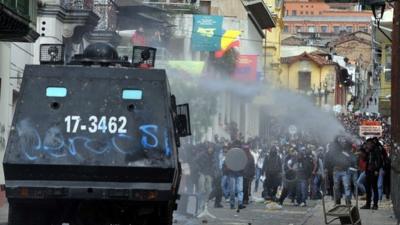 Riot police tanks try to disperse protesters with a water cannon