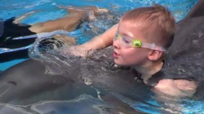 Cieran Kelso swims with Winter the dolphin in Florida