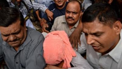 Indian policemen escort the accused