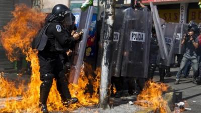 Mexican police stand amid flames from an incendiary device during protests in Mexico City