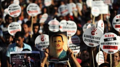 A protester holds a portrait of Syrian President Bashar al-Assad during a rally on September 1,