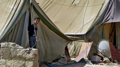 A Syrian refugee boy looks outside his tent, at a temporary refugee camp in the eastern Lebanese town of Marj