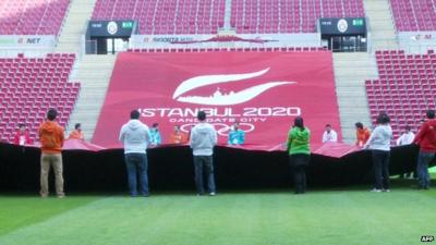 People standing in front of a large banner that reads 'Istanbul 2020'