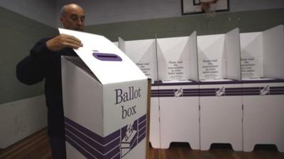 An electoral officer at the Balmoral polling station puts together ballot boxes and voting booths in Sydney