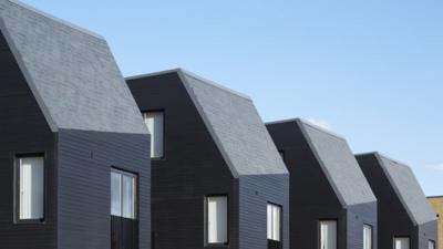 Newhall Be rooftops against sky