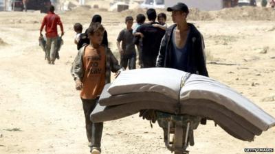 Boys moving mattresses around Zaatari refugee camp in Jordan