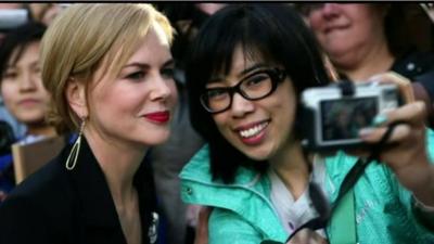 Nicole Kidman poses with a fan