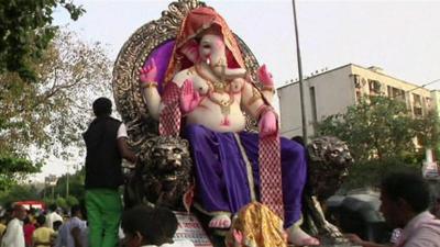 A statue of Lord Ganesh is paraded through the streets