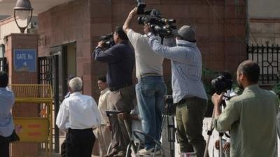 Photojournalists take pictures of a Delhi police van believed to be carrying the accused