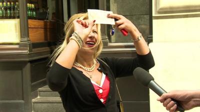 A lady looks at the new plastic bank note