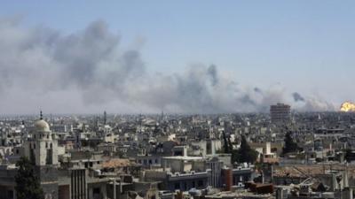 Flame and smoke rise from the district of south-eastern Wadi al-Dhahab in Homs